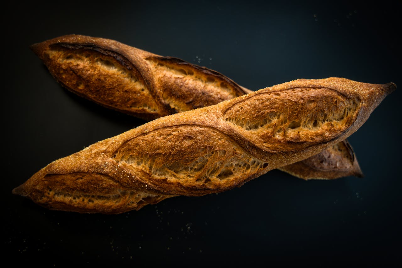 services-06 Golden, crisp artisan baguettes perfectly baked on a dark background. Captured in Berlin, Germany.