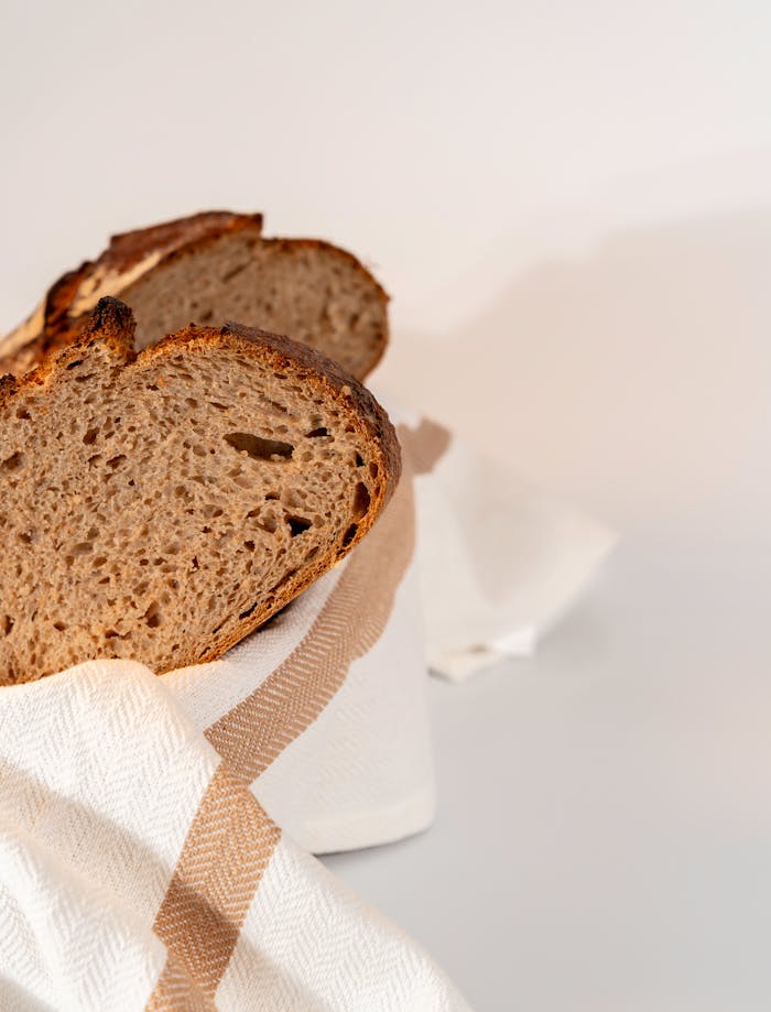services-01 Close-up of fresh artisan sourdough bread slices on a linen cloth, perfect for food photography.